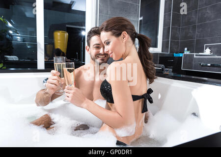 Schöne junge paar entspannende zusammen und trinken Champagner im Whirlpool. Stockfoto