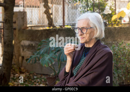 Ältere Frau, die Tasse Kaffee im freien Stockfoto