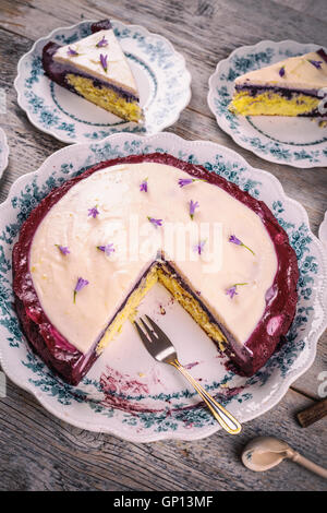 Heidelbeer-Sahne-Torte mit Blume verziert Stockfoto