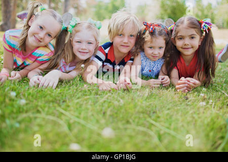 Reihe von sorglosen Kinder liegen auf dem grünen Rasen Stockfoto