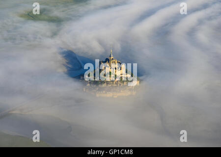 LUFTAUFNAHME. Abbey auf einem isolierten Gipfel über dem Morgennebel. Mont Saint-Michel, Manche, Normandie, Frankreich. Stockfoto