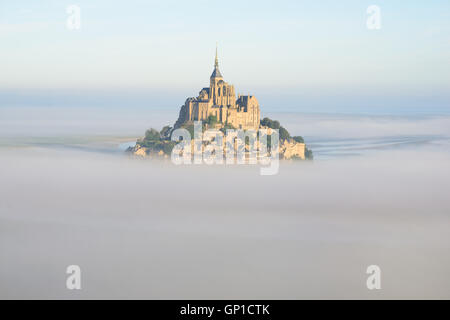 LUFTAUFNAHME. Abbey auf einem isolierten Gipfel über dem Morgennebel. Mont Saint-Michel, Manche, Normandie, Frankreich. Stockfoto