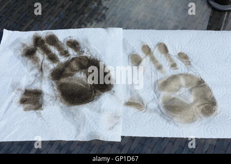 Zwei schmutzige Handabdrücke auf weißen Küchenpapier nach der Reinigung der Glasplatte des Tisches Terrasse. Stockfoto