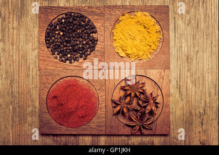 hölzernen Behältern mit Paprika, Pfeffer-Körner, Anis und curry Stockfoto