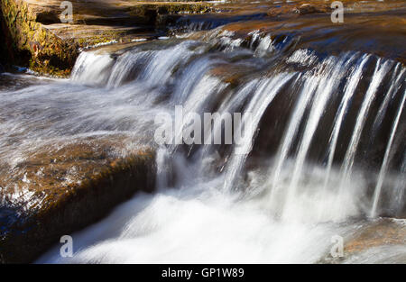 Reihe von Felsen, die ein kleiner Bach über läuft Stockfoto