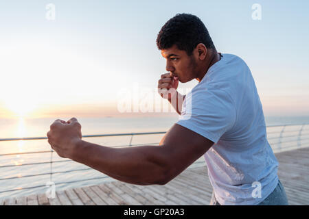 Athletische afroamerikanischen jungen Sportler Boxen am Pier in der früh Stockfoto