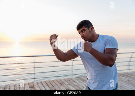 Ernster afroamerikanischen jungen Mann Sportler Boxen im Freien am Morgen Stockfoto