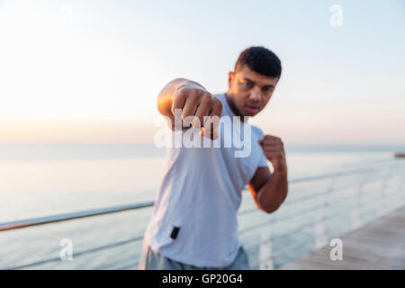 Sportlicher afroamerikanischen jungen Mann Boxer stehen und tun Boxtraining am pier Stockfoto