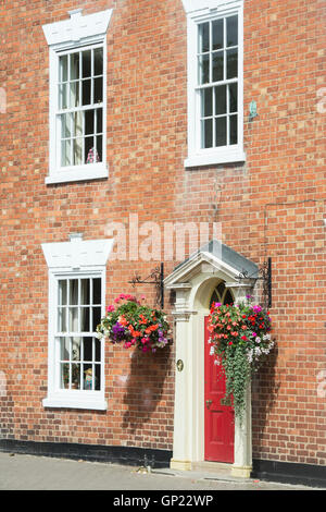 Hängende Blumenkörbe auf der Vorderseite eines Stadthauses. Bilovec, Worcestershire, UK Stockfoto