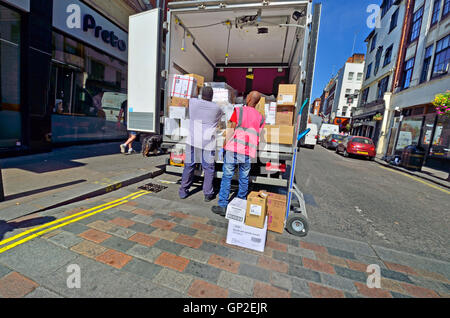 London, England, Vereinigtes Königreich. Zwei Männer entladen ein LKW auf der Straße Stockfoto