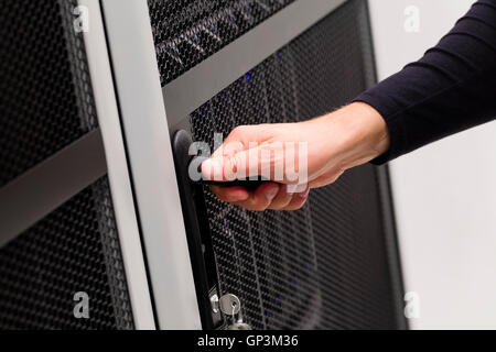 IT-Techniker öffnet Tür zu Server-Rack im Rechenzentrum Stockfoto
