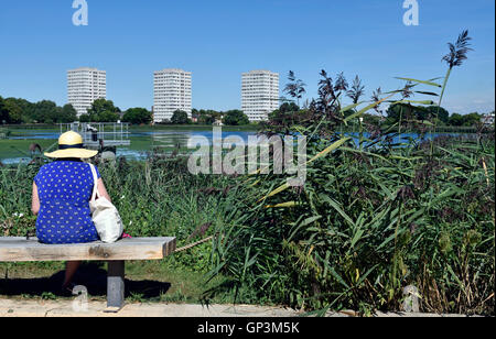 Dame mit Stroh Hut sitzt auf einer Bank am Woodberry Feuchtgebiete. Die Reserve wird von den London Wildlife Trust verwaltet. Stockfoto