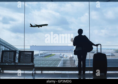 Reisenden im Blick auf die startenden Flugzeug Flughafen Stockfoto