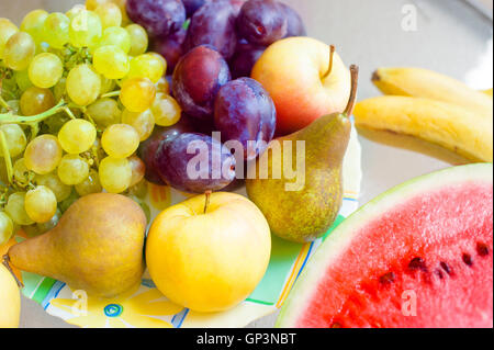Teller mit Obst - Äpfel, Birnen, Pflaumen, Weintrauben. gesunde Ernährung-Konzept Stockfoto