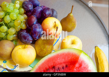 Teller mit Obst - Äpfel, Birnen, Pflaumen, Weintrauben. gesunde Ernährung-Konzept Stockfoto