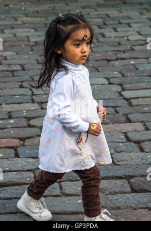 Ein kleines Mädchen läuft auf dem Stein gepflasterten Plaza de San Francisco in der historischen Altstadt Quito, Ecuador. Stockfoto