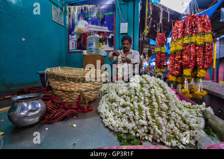 Menschen Sie kaufen und verkaufen Blumen und Girlanden auf dem Blumenmarkt in Mysore, Karnataka, Indien. Stockfoto