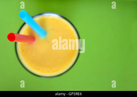 Mango Lassi auf grünem Hintergrund. Mango-Smoothie mit Mango und Joghurt, Joghurt gemacht. Selektiven Fokus. Ansicht von oben. Stockfoto