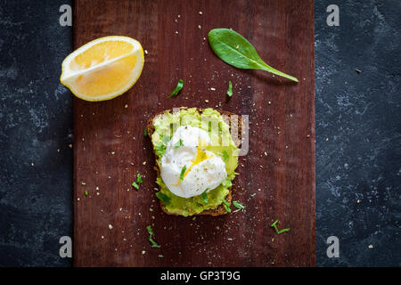 Pochiertes Ei und zerdrückte Avocado auf Roggen Toast, Ansicht von oben. Gesunde Ernährung Stockfoto