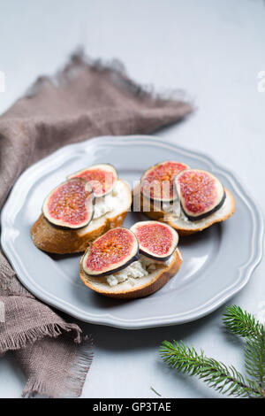 Bruschetta mit Feigen und Ziegenkäse auf einem Teller. Urlaub Vorspeise. Selektiven Fokus Stockfoto