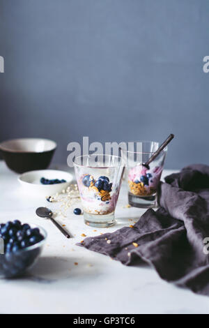 Gesundes Frühstück-Parfait mit hausgemachtem Müsli, Joghurt und Blaubeeren auf einen Marmortisch. Durchtrainierten Bild. Essen Stilleben Stockfoto