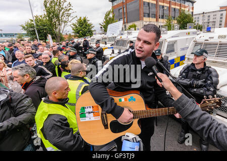 Ein Mann singt "Die Männer hinter the Wire" bei einem irischen Republikaner Protest, nachdem sie fortfahren entlang einer Straße gehindert wurden. Stockfoto