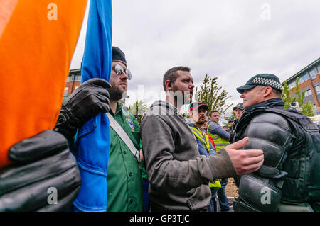 Eine Anzahl von Männern, darunter auch einige in paramilitärische Uniformen gekleidet und mit Fahnen, von Verfahren, Belfast City Centre von der Polizei verhindert sind. Stockfoto