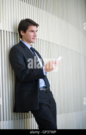 Geschäftsmann von SMS-Nachrichten während der Einnahme einer Pause Stockfoto