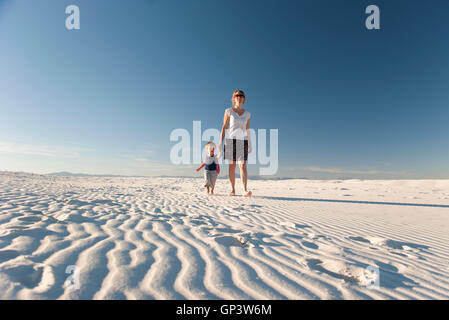 Mutter und Sohn gehen auf Düne, White Sands National Monument, New Mexico, USA Stockfoto