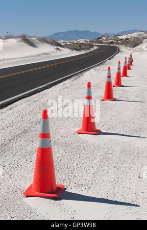 Leitkegel entlang einer asphaltierten Straße durch White Sands National Monument, New Mexico, USA Stockfoto