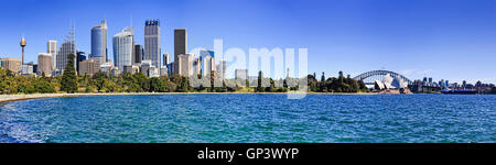 Breites Panorama des Hafens von Sydney mit Hochhäusern und Royal Botanic Garden gesehen über Bucht an einem sonnigen Tag. Stockfoto