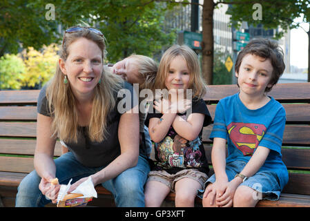 Familie zusammen sitzen auf Bank, Porträt Stockfoto