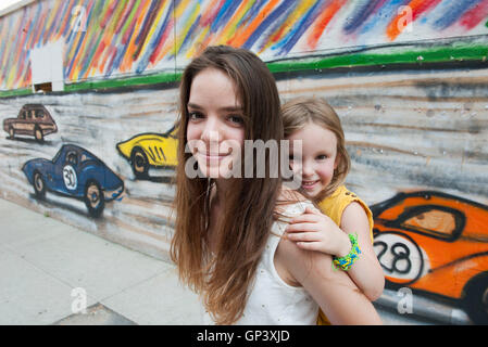 Teenager-Mädchen geben ihre kleine Schwester eine Huckepack Fahrt, Porträt Stockfoto