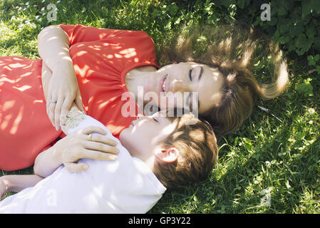 Mutter und Sohn Nickerchen auf dem Rasen Stockfoto