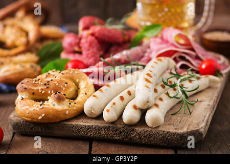 Glas Bier, Brezeln und verschiedene Würste auf hölzernen Hintergrund. Oktoberfest. Stockfoto