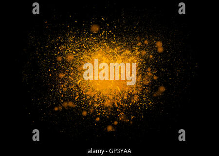 Frieren Sie Bewegung der bunten hellgelbes Pulver explodiert isolierten auf schwarzen Hintergrund dunkel. Abstrakte Muster Farbe Staubwolke. Beson- Stockfoto