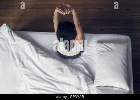 Frau sitzt am Rand des Ausdehnens Bett Stockfoto