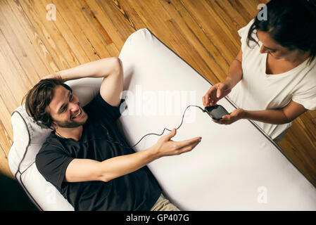 Frau neidisch auf Mannes smartphone Stockfoto