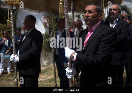 Männer halten einen Sonnenschirm in Corpus Christi fest in El Gastor, Sierra de Cadiz, Andalusien, Spanien Stockfoto