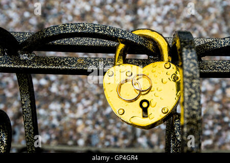 Trauringe liegen auf einer hängenden Sperre von goldener Farbe Stockfoto