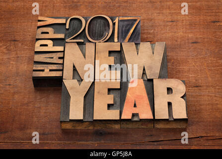 Glückliches Neujahr 2017 Grußkarte - Text in Vintage Buchdruck Holzart Blöcken auf einem hölzernen Grunge-Hintergrund Stockfoto