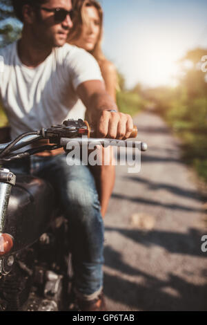 Aufnahme des jungen Paares auf dem Motorrad abgeschnitten. Mann reitet auf einem Motorrad mit Freundin an einem sonnigen Tag. Stockfoto