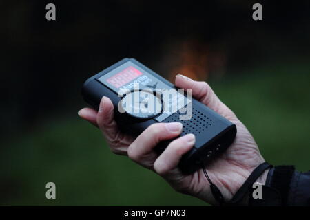 Eine Frau hält einen Fledermausdetektor auf geführte Fledermaus Identifikation Abendspaziergang in Derbyshire, England UK - Sommer Modell veröffentlicht Stockfoto