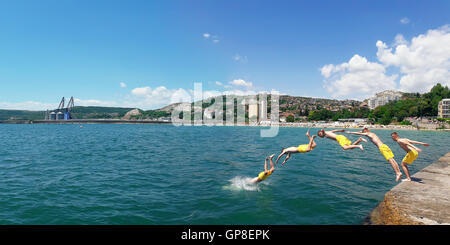 Junge springt in das Wasser des Meeres am Strand von Balchik, Bulgarien. Sommer Urlaub Hintergrund. Freude, Glück und Erholung-Konzept Stockfoto