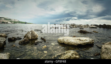 Seelandschaft der Steinstrand mit einem dramatischen Wolkenhimmel. Schöne Aussicht an der Küste des Schwarzen Meeres in der Stadt Balchik, Bulgarien. Stockfoto