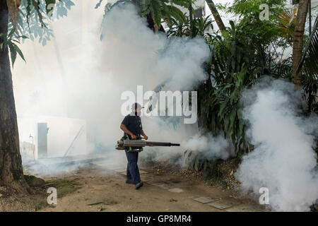 Ein Arbeiter Nebel gegen Mücken um eine Eigentumswohnung in Kuala Lumpur, Malaysia. Stockfoto