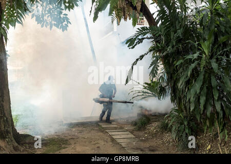 Ein Arbeiter Nebel gegen Mücken um eine Eigentumswohnung in Kuala Lumpur, Malaysia. Stockfoto