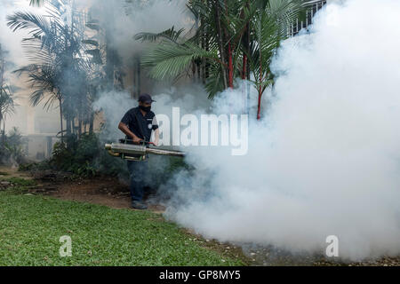 Ein Arbeiter Nebel gegen Mücken um eine Eigentumswohnung in Kuala Lumpur, Malaysia. Stockfoto