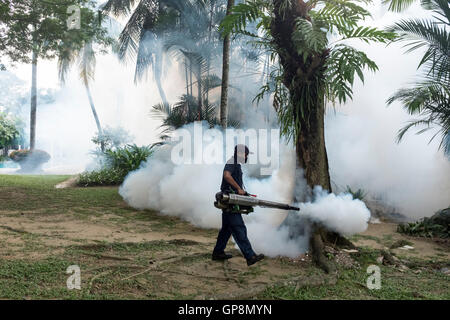 Ein Arbeiter Nebel gegen Mücken um eine Eigentumswohnung in Kuala Lumpur, Malaysia. Stockfoto