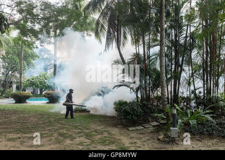 Ein Arbeiter Nebel gegen Mücken um eine Eigentumswohnung in Kuala Lumpur, Malaysia. Stockfoto